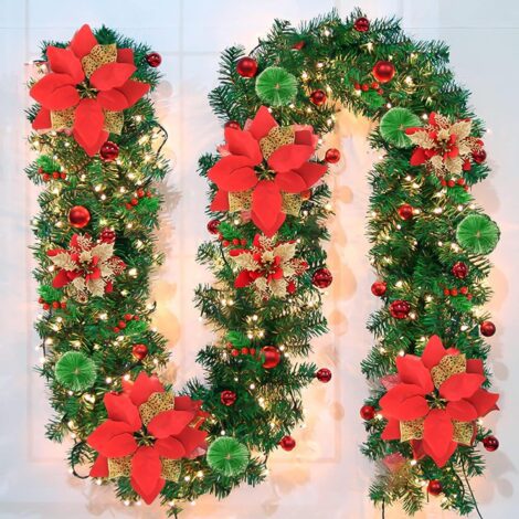 Christmas garland with warm lights, red flowers, balls, berries, snowy pine, perfect for home decor.